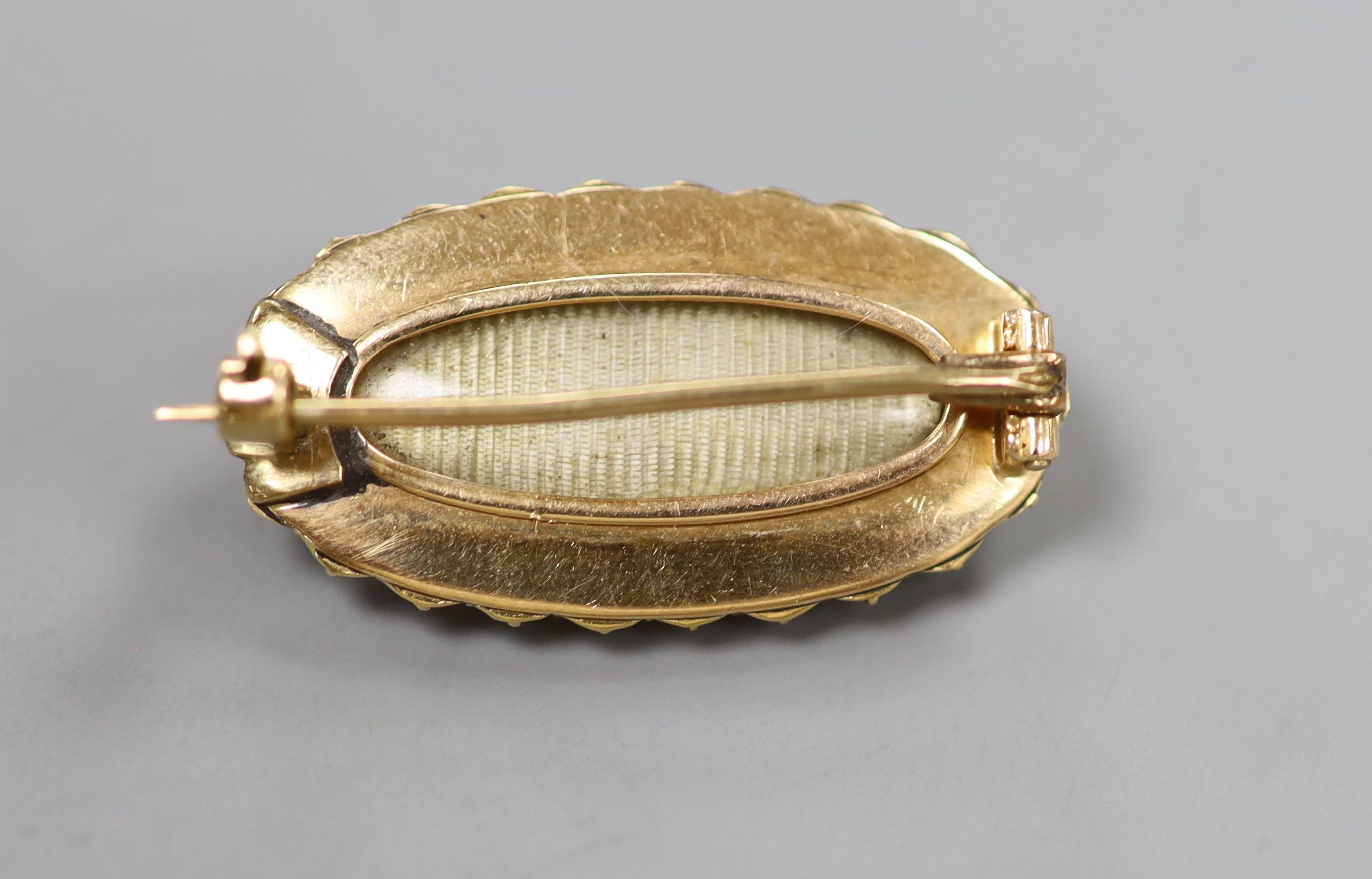 A Victorian yellow metal, blue enamel, seed pearl and diamond set oval brooch, 29mm, gross 6.8 grams,